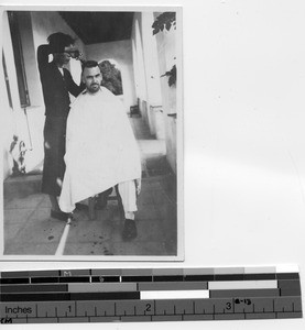 Fr. F. J. Connors getting hair cut at Luoding, Jiangmen, China, 1930