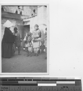 Beggars at an entrance gate in China, 1923