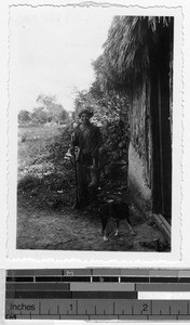 Maya hunter in front of his hut holding an armadillo, Mexico, ca. 1944