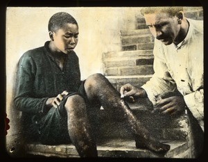 Fr. Bernard Meyer, MM, treating an injured person's leg, China, ca. 1918-1938