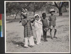 Four school children dressed in ethnic costumes, India, ca.1919-1943