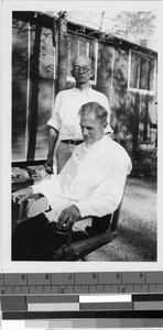 Priest getting a haircut at Granada Japanese Relocation Camp, Amache, Colorado, ca. 1943