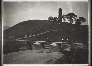 Missionar H. Maier zu Pferd mit seinem Träger über die Brücke. Alte Pagode