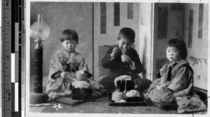 Three children eating noodles, Japan, ca. 1920-1940