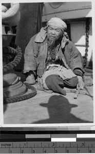 Prisoner sitting on a junk, Wuchow, China, 1930