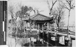 River with bridge and small temple structure, Hong Kong, China, ca.1920