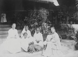 Santalistan/Santal Parganas, Nordindien. Ved trappen til missionshuset på Ebenezer, ca. 1900. Fra venstre: Fru Katharina Heuman - Pastor Surjo Murmus hustru - "Mama"Børresen med santalbarnet Randhon - Mariam, en skolepige på Ebenezer og hunden Truls