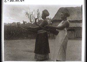 Tuke and Mowue, 2 of the King's Wives, playing the guitar