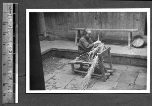 Tibetan woman making something with straw, Tibet, China, ca.1941