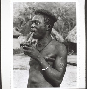 An Mbembe man smoking his pipe