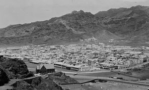 Udsigt over Aden (Crater) med bjergene i baggrunden. Bygningen i forgrunden med spidst tag er den engelsk kirke. I baggrunden Aidrûs-moskeen