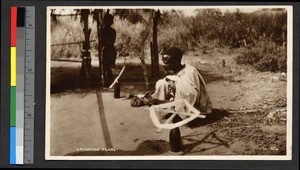 Man spinning flax outdoors, Ghana, ca.1920-1940