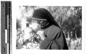 Sr. Marcus Marie, MM, holding a baby, Honolulu, Hawaii, ca. 1935-1955