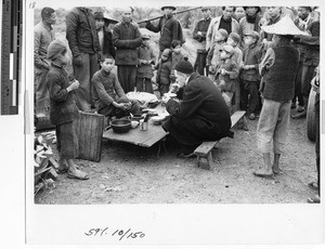 Fr. John McLoughlin eating a meal at Wuzhou, China,1948