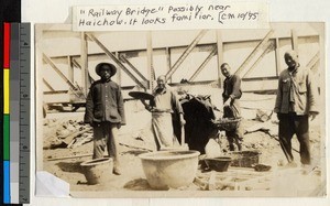 Chinese men standing in front of a railway bridge, Haizhou, Jiangsu, China, ca.1910-1930