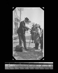 Man giving beggar woman money, Shantou, Guangdong, China, ca.1921-1923