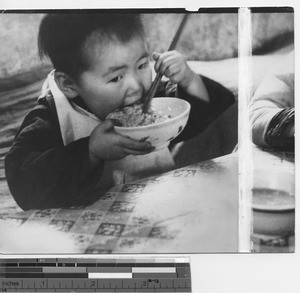 Child eating rice at Fushun, China, 1937