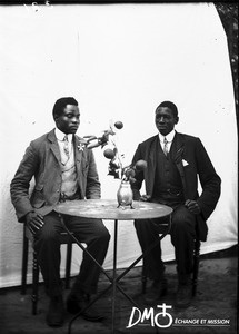 African men sitting at a table, Antioka, Mozambique, ca. 1901-1915