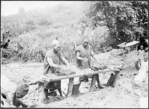 Men pressing bricks into moulds, Tanzania, ca. 1900-1914