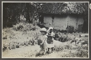 Children in front of thatched house, Tanzania