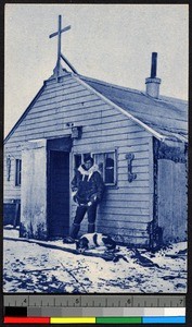 Man and dog before a small wooden chapel, Alaska, ca.1920-1940