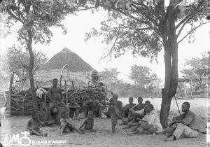 Men and boys drinking beer in Antioka, Mozambique, ca. 1896-1911