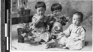 Three children eating from glass dishes, Japan, ca. 1920-1940