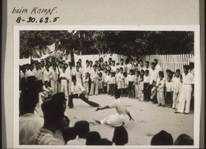 Phases of the mock-battle on the street which takes place before the bridegroom is allowed to go up into the house. Two boys wrestling