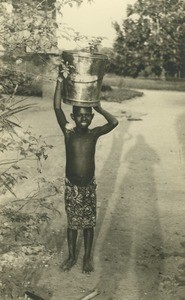 Gabonese girl with a bucket on her head, in Gabon