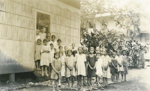 Girls going out of a bamboo hut which serves as a library or as a classroom for religion lessons, Papeete