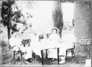 The Rother family, missionary Guth and a planter at a table, Gonja, Tanzania, ca. 1911-1914