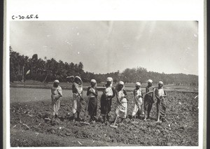 Indian women breaking up clumps of earth