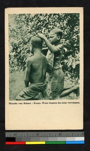 Girl inspecting the hair of a boy, Congo, ca.1920-1940