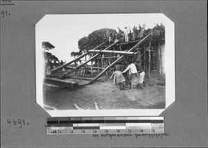 Pulling parts of a roof onto the church building, Mbozi, Tanzania