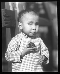 Boy holding some food, China, ca. 1918-1938