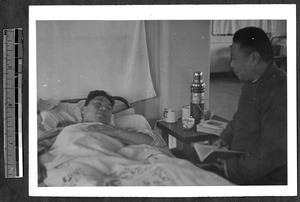 Man reading scripture to patient, Jinan, Shandong, China, 1941