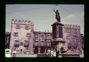 group in front of a monument on a city street