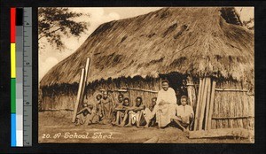 Indigenous teacher and students seated outside a school, Angola, ca.1920-1940