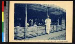 Missionary standing by indigenous men with microscopes, Cameroon, ca.1920-1940