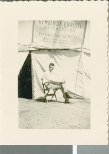 Rudi Walzebuck Sits in Front of a Meeting Tent, Niederrad, Germany, 1952