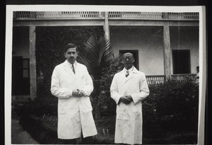 Hans and his assistant Schong in the garden of the hospital in front of the main building for men