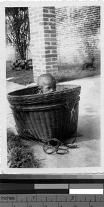 Orphan in a basket, Loting, China, 1935