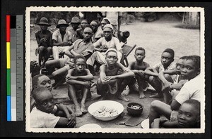 Boys sitting around bowls of food, Congo, ca.1920-1940