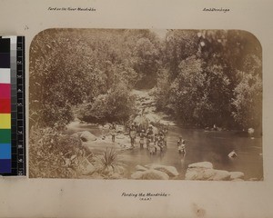 Indigenous men transporting missionary across Mandraka river by filanjana, Madagascar, ca. 1865-1885