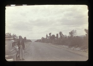 man by car, mountains in the background