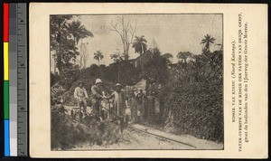 Missionary fathers standing with people outdoors by rail tracks, Congo, ca.1920-1940