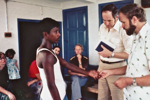 Nilphamari, Bangladesh. En spedalsk drengs deforme fingre bliver demonstreret af læge Jørgen Steiner, DBLM (th) til pastor Ole Christiansen, formand for Dansk Santalmission. Bagerst ses missionær Iver Viftrup og lokale medarbejdere. (Foto fra perioden 1977-79)