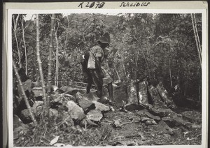 Breaking and carrying stones to rebuild the house in Kumba