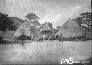 African men sitting in front of huts, Antioka, Mozambique, ca. 1901-1915