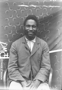 African man sitting on a chair, Matutwini, Mozambique, ca. 1896-1911